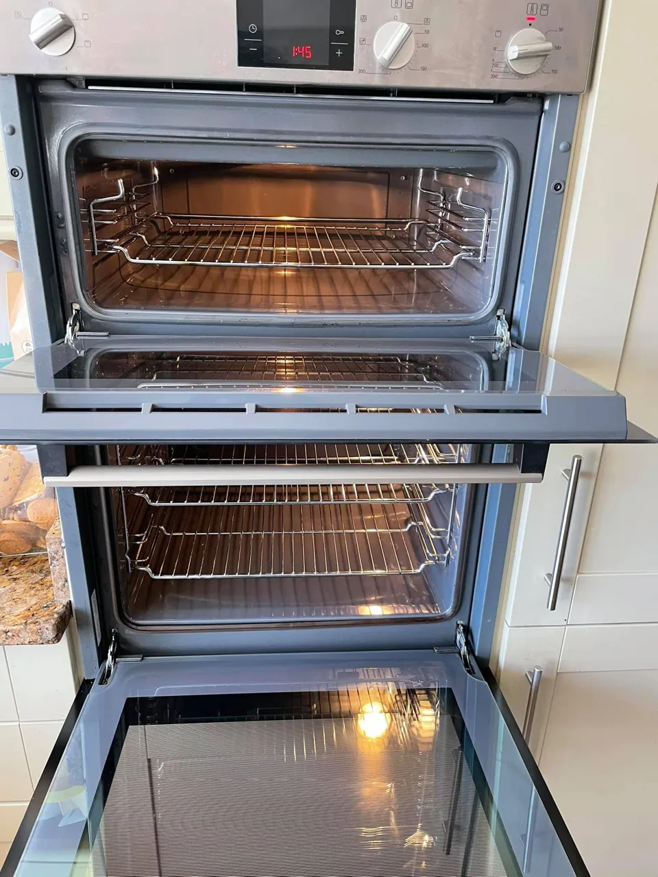 A double built-in oven with the doors open after cleaning