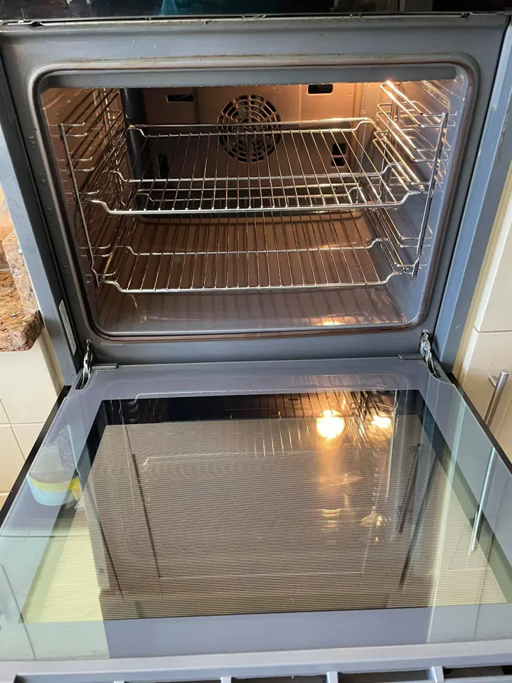 A freshly cleaned oven interior with clean racks and glass