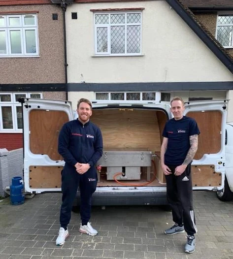 Trainer and trainee standing in front of the training van with the dip tank in the back